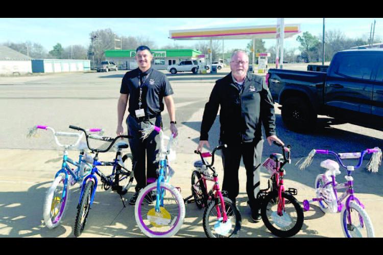Doug Chaffin and Blake Johnson are pictured with 6 bicy - cles that the Holdenville Muscogee Nation Casino gave out to 6 lucky children in Wetumka.