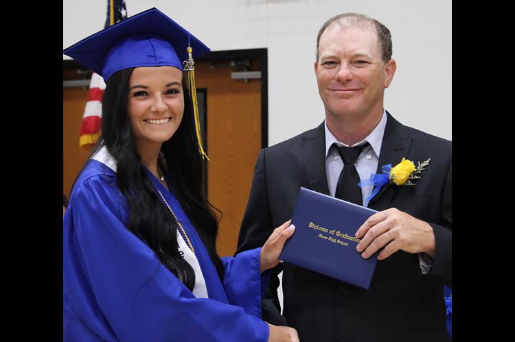 Moss school board member Bryan Smith presents diplomas